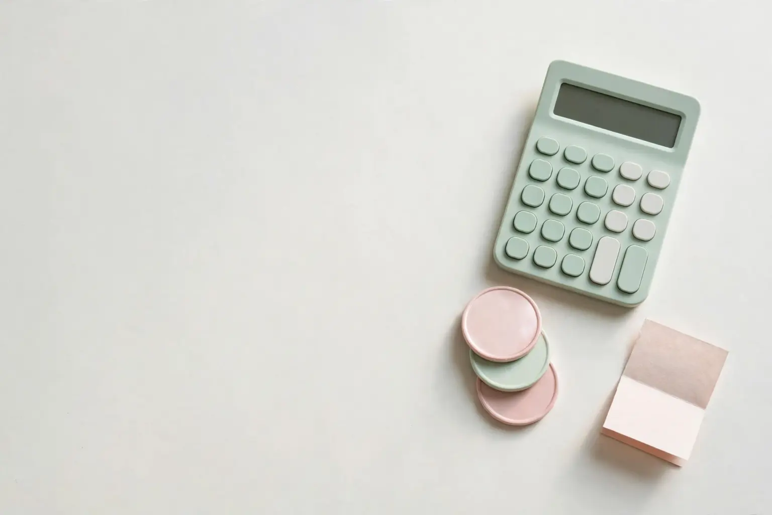 Flat-lay: small calculator beside three stacked pastel coins and a tiny paper invoice, mint green and blush pink palette