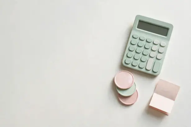 Flat-lay: small calculator beside three stacked pastel coins and a tiny paper invoice, mint green and blush pink palette