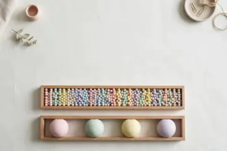 Flat-lay: two long wooden trays side by side on an off-white background, the top one filled with many tiny pastel beads and the lower one holding four large pastel balls