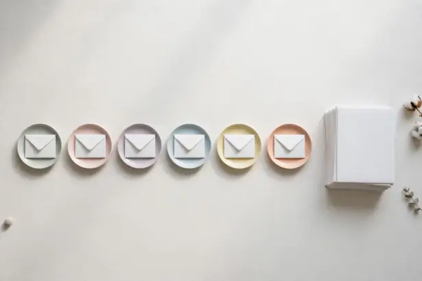 Flat-lay: a neat row of six small white envelopes each resting on its own pastel saucer, with a larger stack of white envelopes waiting beside them