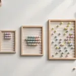Flat-lay: three wooden abacus-style counting frames of different sizes side by side, their pastel beads arranged in a small group, a medium group and a scattered spread