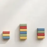Three stacks of colorful wooden blocks at different heights — n8n vs Make vs Zapier cost comparison