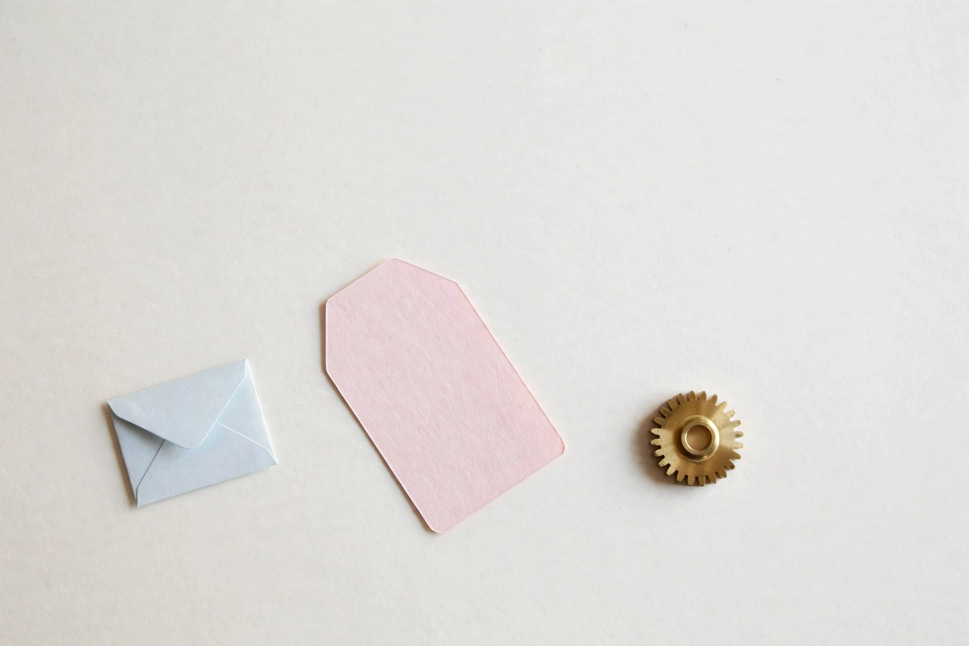 Brass gear beside price tag and envelope — stack pricing
