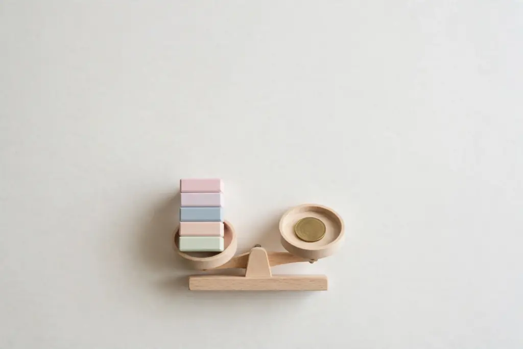 Wooden balance with pastel blocks and brass coin — weighing hosting options