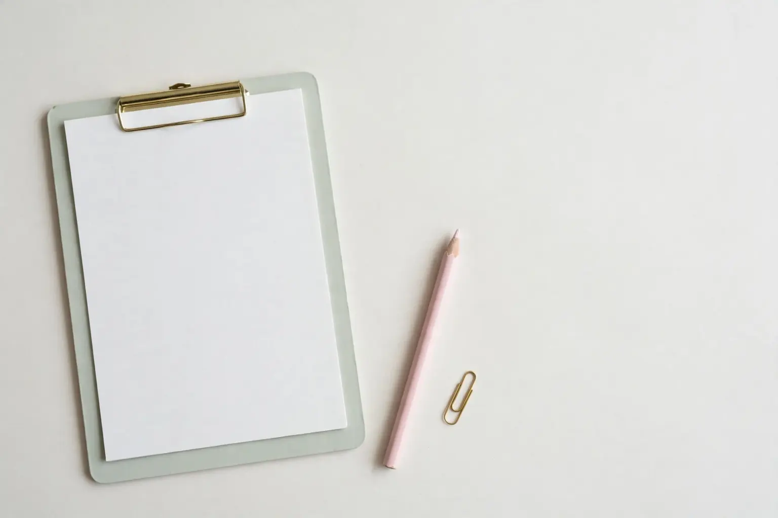 Pastel clipboard with blank score sheet and pencil — benchmarking an AI support agent