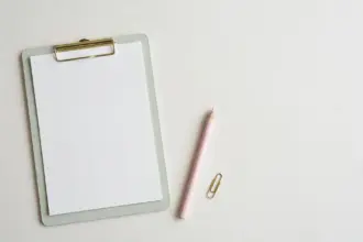 Pastel clipboard with blank score sheet and pencil — benchmarking an AI support agent