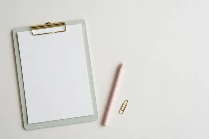 Pastel clipboard with blank score sheet and pencil — benchmarking an AI support agent